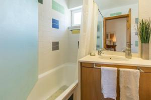 un bagno con vasca, lavandino e specchio di Villa Foz ad Aldeia do Meco Altre 39 foto