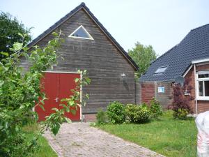 een huis met een rode garage met een driehoek erop bij zonneraai in Nieuweroord