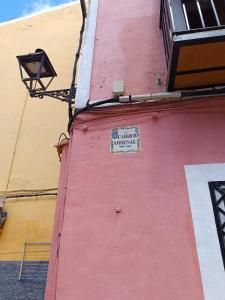 a pink building with a sign on the side of it at Airén - Harbor's Light in Villajoyosa