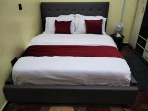 una camera da letto con un letto grande con cuscini rossi di Kukis Place in Embu a Embu
