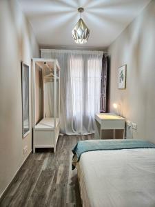 Un dormitorio con una cama, un escritorio y un espejo. en San Blas Place, en Zaragoza