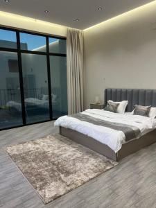 a bedroom with a large bed and a rug at شاليه لدن in Hail