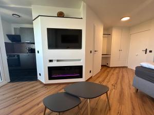 a living room with a tv and a couch and a table at Feinwald Highline Altenau in Altenau