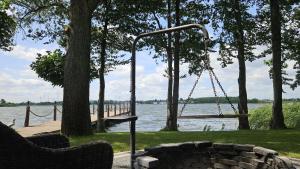 a swing and a bench next to a lake at Domek nad Jeziorem - Wielkopolskie Mazury in Konin