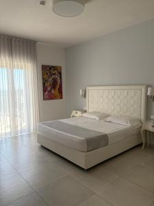una camera da letto con un letto grande e una grande finestra di Hotel Puglia Garden a Vieste
