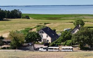 a house with buses parked in front of a field at Bungalow Seeblick Am Achterwasser in Ueckeritz