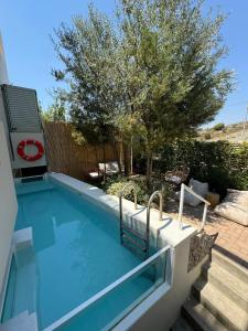 a swimming pool in a yard with a tree at Casa Horizon in Porto Heli