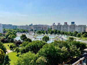 a park with a fountain in the middle of a city at Style and view Bucharest city center aparthotel in Bucharest