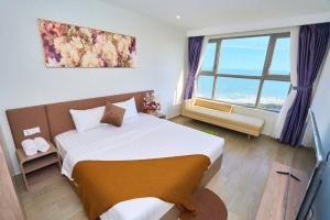 una camera da letto con un letto e una grande finestra di The Sóng Apartment Vũng Tàu - Phươngg's House a Vung Tau