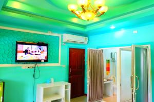 d'une salle de bains aux murs bleus et d'une télévision au plafond. dans l'établissement Rak Kun Resort 2, à Nakhon Sawan 137 autres photos