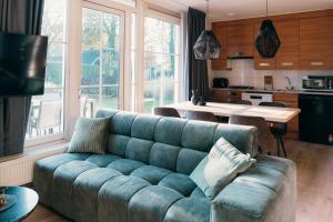 a living room with a blue couch in a kitchen at Bungalow Bunckman Luxury 10 persons in Voorthuizen