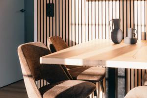 a wooden table with chairs and a vase on it at Bungalow Bunckman Luxury 10 persons in Voorthuizen