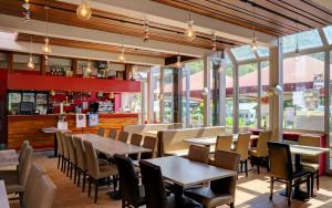 een restaurant met tafels en stoelen en een bar bij Coco Sweet with sanitary in La-Roche-en-Ardenne