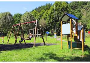 twee kinderen spelen op een schommel in een park bij Coco Sweet with sanitary in La-Roche-en-Ardenne +25 foto's