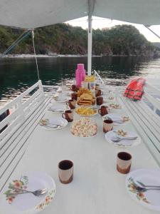 a long table with plates of food on a boat at mama hostel El nido in El Nido +26 photos