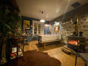 a living room with a table and a fireplace at COSY B&B in Murat