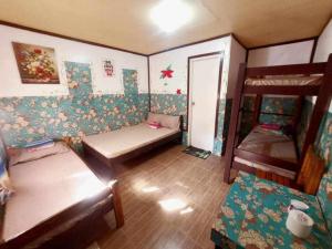 a room with two beds and a bunk bed at mama hostel El nido in El Nido
