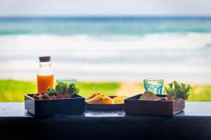 a table with a plate of food and a bottle of juice at Sealord Naithon Beachfront Villa in Nai Thon Beach