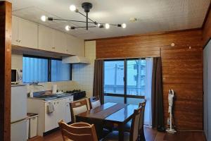 Una cocina con una mesa y un comedor. en パイナガマビーチハウス, en Isla Miyako