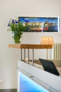 einen Tisch mit einer Blumenvase drauf in der Unterkunft Hotel Am Mühlenteich in Lübeck