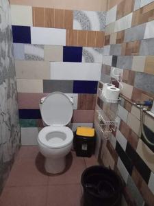 a bathroom with a toilet and a colorful wall at mama hostel El nido in El Nido +40 photos