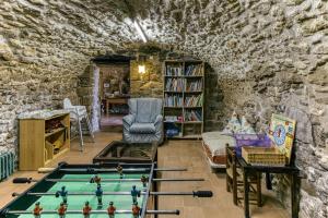 ein Wohnzimmer mit einem Billardtisch in einer Steinwand in der Unterkunft Casa Rural La Pallissa de Llampaies in Llampaies