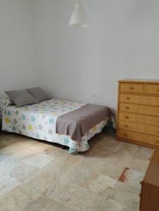 a bedroom with a bed and a wooden dresser at Apartamento Vino Tinto in Valdepeñas