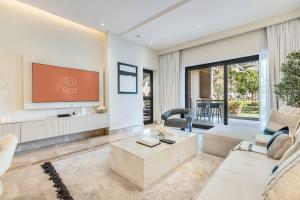 ein Wohnzimmer mit einem weißen Sofa und einem Fernseher in der Unterkunft DAYF-FMT Fairmont Palm with Pool and Beach Access in Dubai