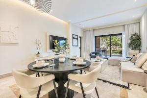 Una sala de estar con una mesa y sillas y un sofá. en DAYF-FMT Fairmont Palm with Pool and Beach Access, en Dubái