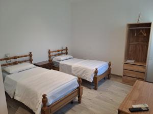 a bedroom with two beds and a wooden table at Il Nido delle Cicogne in Sacca
