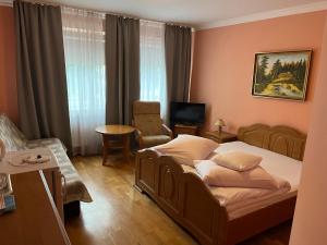a hotel room with a bed and a chair at Rezydencja Szatkowskich in Barlinek