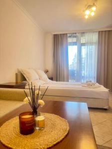 a hotel room with a bed and a table with flowers on it at Marena Studio - Santa Marina, Sozopol in Sozopol