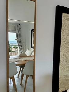 een spiegel in een eetkamer met een tafel en stoelen bij Apartamento Marina Roses 4 in Roses