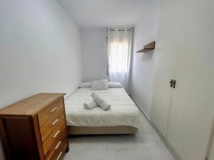 een kleine slaapkamer met een bed en een houten dressoir bij Apartamento Marina Roses 4 in Roses +9 foto's