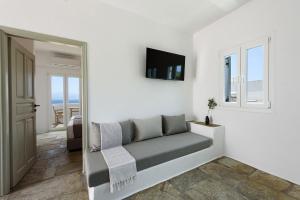 a living room with a couch and a television at Phaedrus Living Paros Cycladic Residences 10 in Kampos Paros