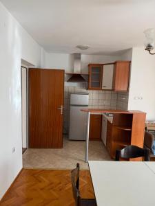 a kitchen with wooden cabinets and a kitchen table at Ivana in Senj +5 photos