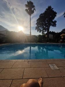 a person laying on the ground near a swimming pool at Agapanthe location in San-Nicolao