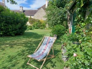 a chair sitting in the grass in a yard at La Solitaire in Saint-Jean-aux-Bois