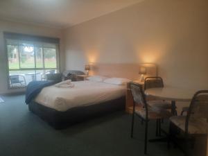 Una habitación de hotel con una cama y una mesa con sillas. en Arthur Phillip Motor Inn, en Cowes 24 fotos más