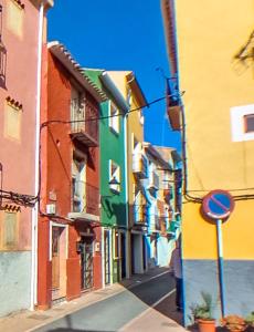 una calle de la ciudad con edificios coloridos y un letrero de la calle en Verdejo - Harbor's Light, en Villajoyosa