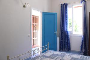 a bedroom with a blue door and a window at Appartamenti da Clarissa in Macari