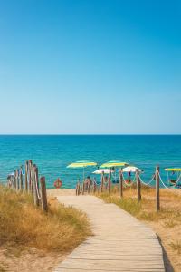 a path leading to a beach with umbrellas at Casa vacanza 'Note di mare' in Torvaianica