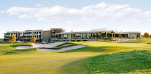 a golf course with a green and a building at Coastal Comfort Pool, Golf, Beach, Room for 8 in Torquay
