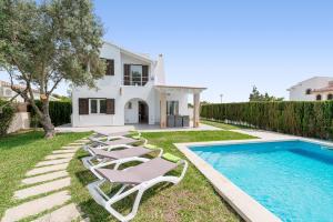 una villa con piscina y tumbonas en Es Racó -Sa Ràpita-, en Llucmajor