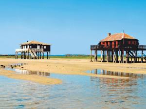 zwei Gebäude an einem Strand neben dem Wasser in der Unterkunft Maison moderne près plage Aiguillon - 2 chambres, terrasse, jardin, parking - Calme et confort - FR-1-420-63 in Arcachon