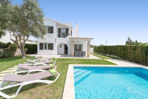 una villa con piscina y tumbonas en Es Racó -Sa Ràpita-, en Llucmajor