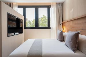 una habitación de hotel con una cama y un televisor en Dobo Madrid Betanzos, en Madrid 12 fotos más
