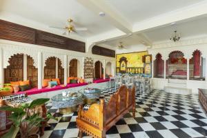 una hall con pavimento a scacchi e mobili rosa di SaffronStays Rang Havelii - Superior room in heritage haveli near City Palace with rooftop chhatri & pool in Udaipur a Udaipur