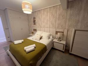 a bedroom with a bed with towels on it at Alojamiento Mar y Bienestar in Laredo