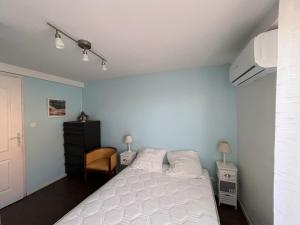 a bedroom with a white bed and a chair at Maison familiale à Arcachon avec climatisation - FR-1-319-420 in Arcachon